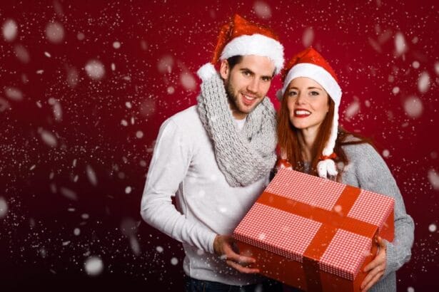 couple-with-christmas-gift-dressed-with-winter-clothes-santa-hat-snow-red-background_23-2147576866