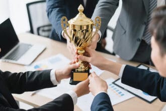 diverse-business-team-celebrating-corporate-success-with-golden-trophy-modern-office-young-professionals-cheerfully-holding-award-team-victory-moment_1240080-558