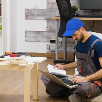 furniture-assembly-worker-uses-laptop-consult-instructions-handyman-doing-good-job_482257-24842