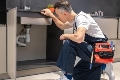 man-kneeling-down-touching-sink-inspecting-pipes_259150-58251