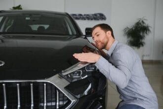 visiting-car-dealership-handsome-bearded-man-is-stroking-his-new-car-smiling_255667-52596