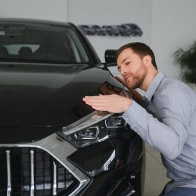 visiting-car-dealership-handsome-bearded-man-is-stroking-his-new-car-smiling_255667-52596