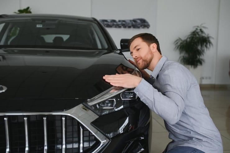 visiting-car-dealership-handsome-bearded-man-is-stroking-his-new-car-smiling_255667-52596