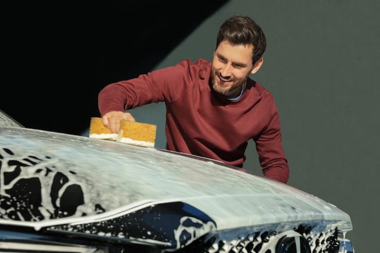 worker-washing-auto-with-sponge-outdoor-car-wash_495423-51367