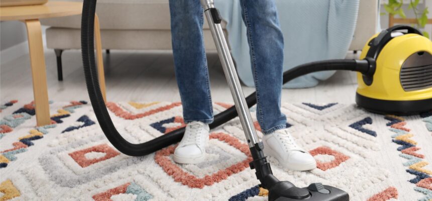 man-with-vacuum-cleaning-carpet-living-room-closeup